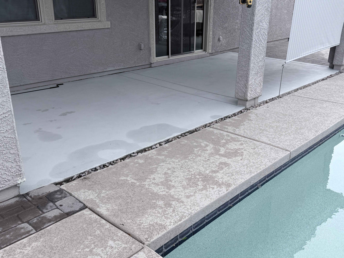 Poolside patio showing an outdoor roller shade and ShadeLock ground anchor connections along the patio edge